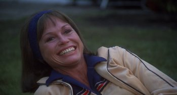 Movie still from “Ordinary People” (1980), directed by Robert Redford – A woman smiling and sitting on the grass; Close Up shot, Low angle
