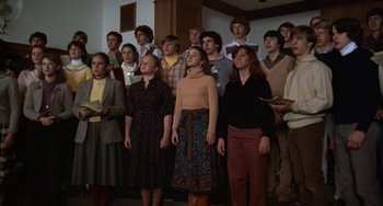 Movie still from “Ordinary People” (1980), directed by Robert Redford – A group of young people standing in a room singing together; Medium shot, High angle