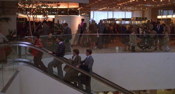Movie still from “Ordinary People” (1980), directed by Robert Redford – A group of people riding an escalator in a shopping mall; Wide shot, High angle