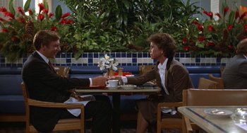 Movie still from “Ordinary People” (1980), directed by Robert Redford – Two people sitting at a table with a cup of coffee in front of them; Wide shot, High angle