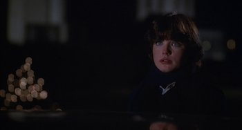 Movie still from “Ordinary People” (1980), directed by Robert Redford – A woman sitting at a table in a dark room; Close Up shot, Over the shoulder angle