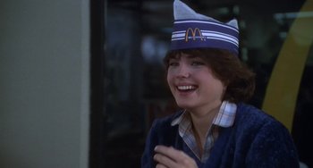 Movie still from “Ordinary People” (1980), directed by Robert Redford – A woman wearing a mcdonald's hat while smiling; Medium shot, Over the shoulder angle