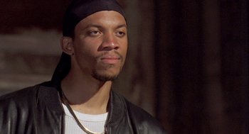 Movie still from “Original Gangstas” (1996), directed by Larry Cohen – A person wearing a black hat; Close Up shot, Low angle