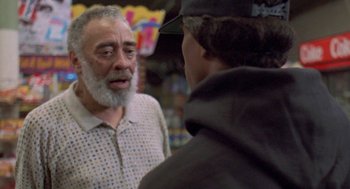Movie still from “Original Gangstas” (1996), directed by Larry Cohen – A man talking to another man in front of a store window; Close Up shot, Over the shoulder angle