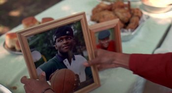 Movie still from “Original Gangstas” (1996), directed by Larry Cohen – A man holding a picture of himself holding a basketball; Extreme Close Up shot, Over the shoulder angle