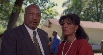 Movie still from “Original Gangstas” (1996), directed by Larry Cohen – A man and a woman standing next to each other; Close Up shot, Low angle