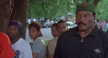 Movie still from “Original Gangstas” (1996), directed by Larry Cohen – A group of people standing next to each other on a sidewalk; Close Up shot, Low angle