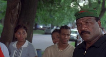 Movie still from “Original Gangstas” (1996), directed by Larry Cohen – A group of people standing next to each other on a sidewalk; Close Up shot, Low angle