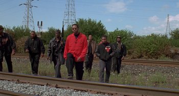 Movie still from “Original Gangstas” (1996), directed by Larry Cohen – A group of men standing next to each other on train tracks; Wide shot, Low angle
