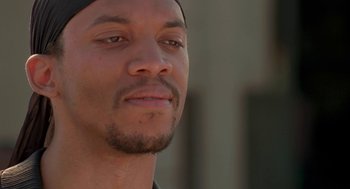 Movie still from “Original Gangstas” (1996), directed by Larry Cohen – A man's face in front of a building; Close Up shot, Over the shoulder angle
