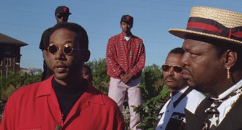 Movie still from “Original Gangstas” (1996), directed by Larry Cohen – A group of men standing next to each other in a field; Medium shot, Low angle