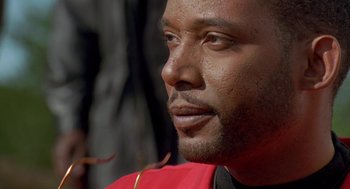 Movie still from “Original Gangstas” (1996), directed by Larry Cohen – A person wearing a red shirt; Close Up shot, Low angle