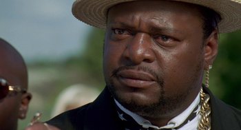 Movie still from “Original Gangstas” (1996), directed by Larry Cohen – A person wearing a hat; Close Up shot, Over the shoulder angle