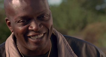 Movie still from “Original Gangstas” (1996), directed by Larry Cohen – A person with a smile on his face; Close Up shot, Low angle