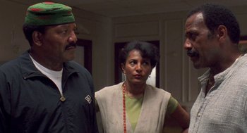 Movie still from “Original Gangstas” (1996), directed by Larry Cohen – A group of people standing next to each other in a room; Medium shot, Low angle