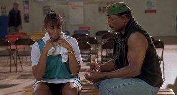 Movie still from “Original Gangstas” (1996), directed by Larry Cohen – A man and a woman sitting on a bench; Medium shot, Over the shoulder angle