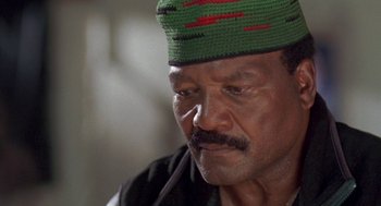 Movie still from “Original Gangstas” (1996), directed by Larry Cohen – An older man wearing a green and red hat; Close Up shot, Low angle