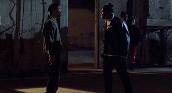 Movie still from “Original Gangstas” (1996), directed by Larry Cohen – Two men are facing each other in the dark; Wide shot, Over the shoulder angle