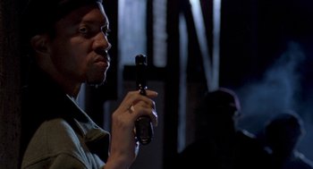 Movie still from “Original Gangstas” (1996), directed by Larry Cohen – A man is holding a cell phone up to his face; Close Up shot, Over the shoulder angle