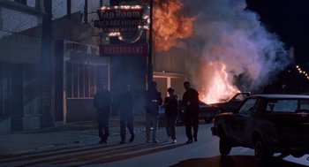 Movie still from “Original Gangstas” (1996), directed by Larry Cohen – A group of people standing on the side of the street; Wide shot, Low angle