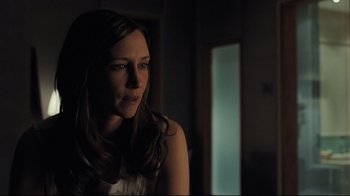 Movie still from “Orphan” (2009), directed by Jaume Collet-Serra – A beautiful woman sitting in a dark room; Close Up shot, Over the shoulder angle