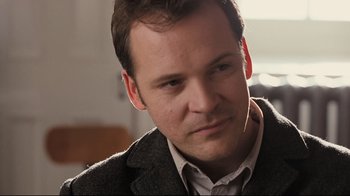 Movie still from “Orphan” (2009), directed by Jaume Collet-Serra – A person wearing a suit and tie; Close Up shot, Over the shoulder angle