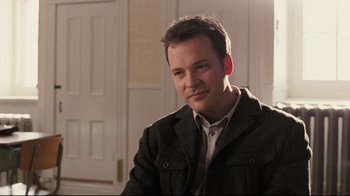 Movie still from “Orphan” (2009), directed by Jaume Collet-Serra – A person sitting in a room; Close Up shot, Over the shoulder angle