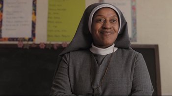Movie still from “Orphan” (2009), directed by Jaume Collet-Serra – A woman in a nun's outfit smiling for the camera; Close Up shot, Low angle