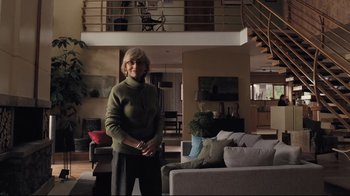 Movie still from “Orphan” (2009), directed by Jaume Collet-Serra – A woman standing in a living room next to a couch; Wide shot, Low angle
