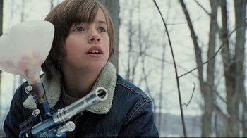 Movie still from “Orphan” (2009), directed by Jaume Collet-Serra – A young boy holding a gun in his hands; Close Up shot, Low angle