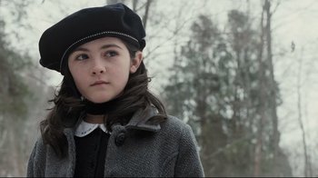 Movie still from “Orphan” (2009), directed by Jaume Collet-Serra – A young girl wearing a black hat and a coat; Close Up shot, Low angle