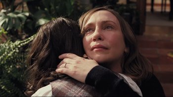 Movie still from “Orphan” (2009), directed by Jaume Collet-Serra – A woman hugging another woman with her hands on her chest; Close Up shot, Over the shoulder angle