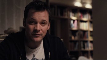 Movie still from “Orphan” (2009), directed by Jaume Collet-Serra – A person sitting in front of a bookshelf; Close Up shot, Over the shoulder angle