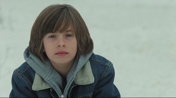 Movie still from “Orphan” (2009), directed by Jaume Collet-Serra – A young boy with brown hair wearing a blue jacket; Close Up shot, Low angle