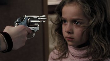Movie still from “Orphan” (2009), directed by Jaume Collet-Serra – A young girl holding a gun pointed at a person; Close Up shot, High angle