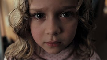 Movie still from “Orphan” (2009), directed by Jaume Collet-Serra – A young girl's face looking at the camera; Close Up shot, High angle