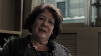 Movie still from “Orphan” (2009), directed by Jaume Collet-Serra – An older woman with short brown hair wearing a black top; Close Up shot, Over the shoulder angle