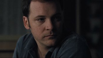 Movie still from “Orphan” (2009), directed by Jaume Collet-Serra – A person sitting down with his head resting on his arm; Close Up shot, Over the shoulder angle