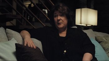 Movie still from “Orphan” (2009), directed by Jaume Collet-Serra – A woman sitting on top of a couch in a living room; Close Up shot, Over the shoulder angle
