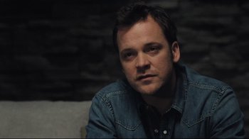 Movie still from “Orphan” (2009), directed by Jaume Collet-Serra – A person sitting on a couch; Close Up shot, Over the shoulder angle