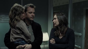 Movie still from “Orphan” (2009), directed by Jaume Collet-Serra – A man and a woman talk to a little girl; Medium shot, Over the shoulder angle