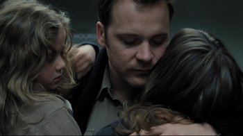 Movie still from “Orphan” (2009), directed by Jaume Collet-Serra – A group of people hugging each other on a bus; Close Up shot, Low angle