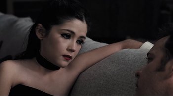 Movie still from “Orphan” (2009), directed by Jaume Collet-Serra – A woman sitting on top of a gray couch; Close Up shot, High angle