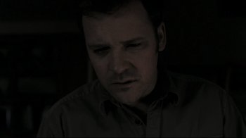 Movie still from “Orphan” (2009), directed by Jaume Collet-Serra – A person wearing a button up shirt; Close Up shot, High angle