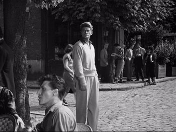 Movie still from “Orpheus” (1950), directed by Jean Cocteau – Black and white photograph of people on a street; Wide shot, Low angle