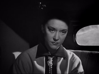 Movie still from “Orpheus” (1950), directed by Jean Cocteau – A black - and - white photo of a woman sitting in the back of a car; Close Up shot, Low angle