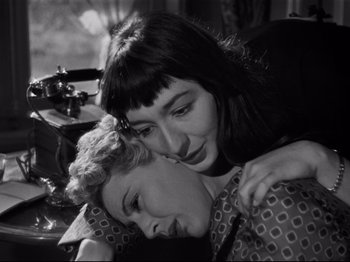 Movie still from “Orpheus” (1950), directed by Jean Cocteau – Two women are hugging each other in a black and white photo; Close Up shot, High angle