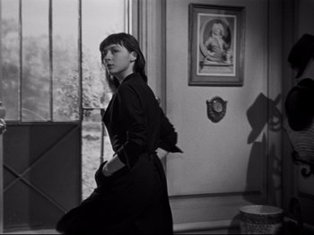 Movie still from “Orpheus” (1950), directed by Jean Cocteau – A black and white photo of a woman in a room; Medium shot, Low angle