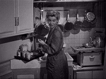 Movie still from “Orpheus” (1950), directed by Jean Cocteau – An old photo of a woman standing in a kitchen; Medium shot, High angle