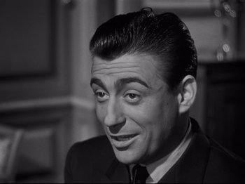 Movie still from “Orpheus” (1950), directed by Jean Cocteau – A black - and - white photo of a man in a suit and tie; Close Up shot, High angle